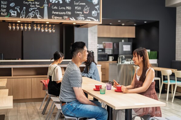 Un café moderne avec un menu écrit à la craie, des tables et des chaises en bois.