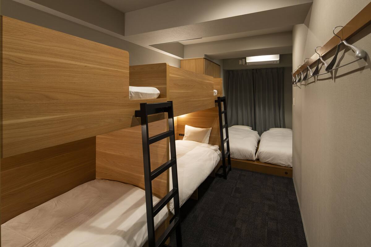 Una habitación de hotel con literas, un escritorio y un armario.