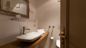 A bathroom with a white sink, a mirror with an ornate frame, and a wooden countertop. - Forsthof (Steinheim an der Murr)