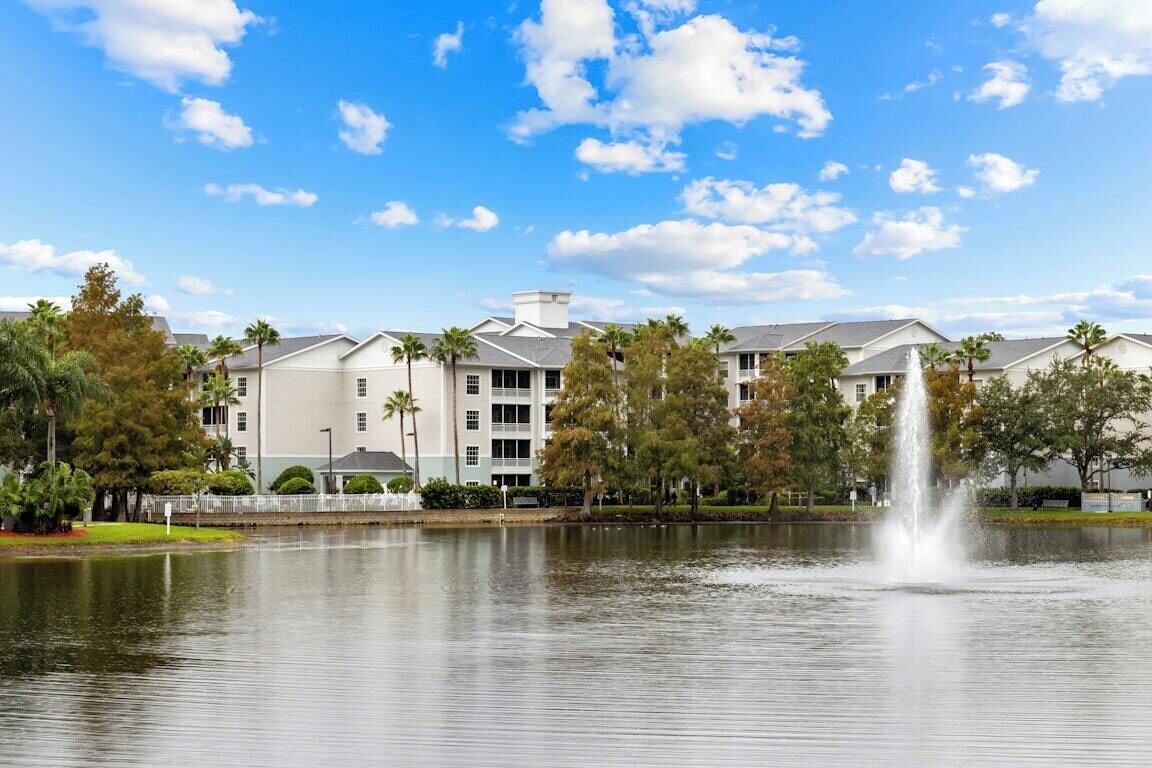 A hotel with a lake view, a fountain, and a row of buildings with a uniform architectural style.