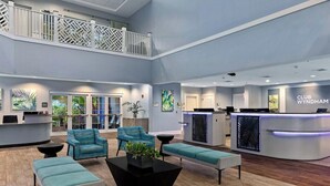 Un lobby moderno con una recepción, zona de estar y una escalera.