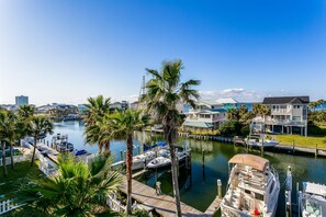 A marina with docked boats, a waterfront property with a dock, and a clear view of the water.