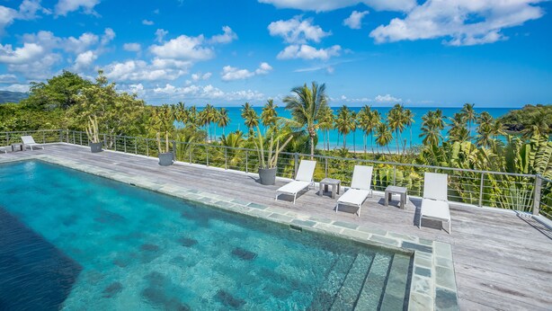 A clear blue sky, a swimming pool with lounge chairs, and a view of the ocean. - Luxury Contemporary Villa with Sea View & Private Pool – Las Terrenas STARLINK (Las Terrenas)
