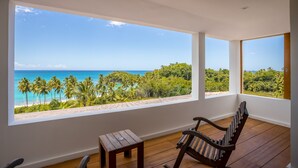 A room with large windows overlooking a beach and lush greenery. - Luxury Contemporary Villa with Sea View & Private Pool – Las Terrenas STARLINK (Las Terrenas)