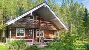 A wooden cabin with a sloped roof, a front porch, and a small deck. - Saarijärvi by Interhome (Sulkava)