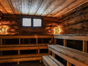 A wooden cabin interior with a bench and a window. - Puikkokoski by Interhome (Kontiomäki)