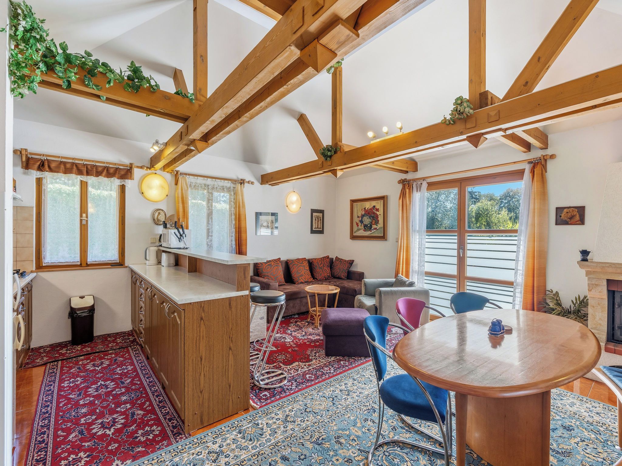 Un salon chaleureux avec un plafond en bois, un canapé, une table basse et une cheminée.