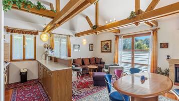 Un salon chaleureux avec un plafond en bois, un canapé, une table basse et une cheminée.