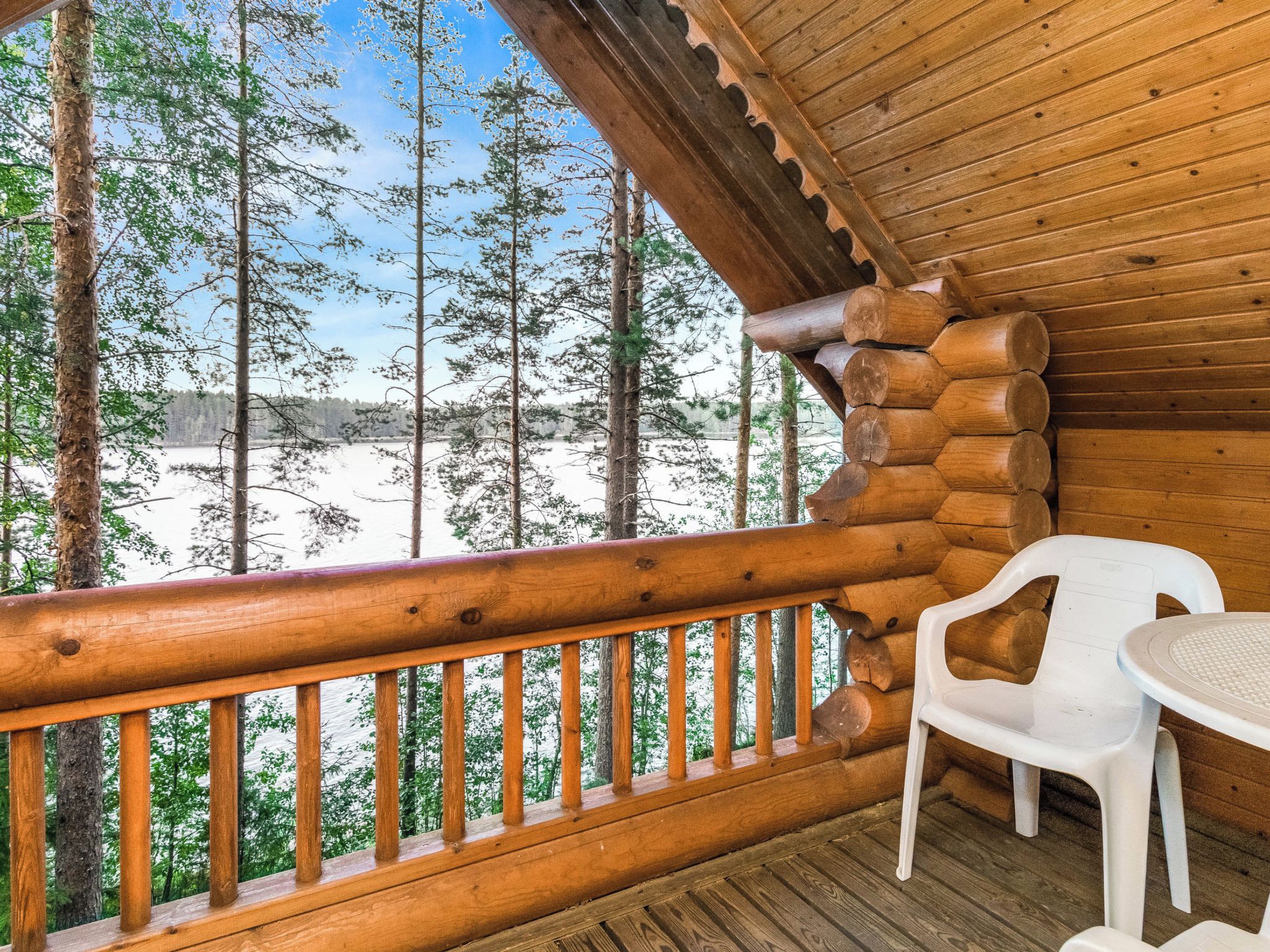 Une cabane en bois dotée d’un balcon donnant sur un paysage enneigé.