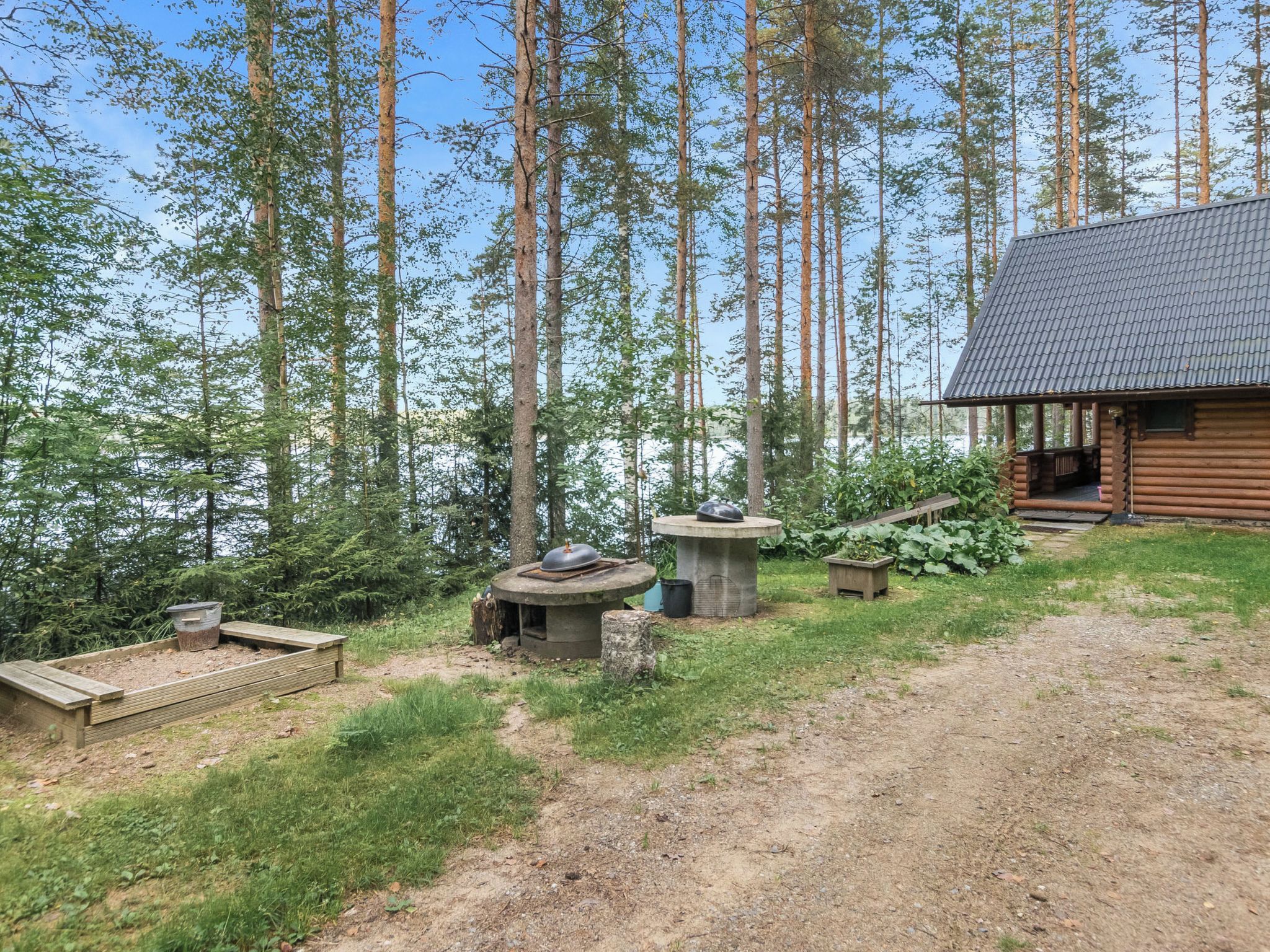 Een chalet met terras, omgeven door bos.