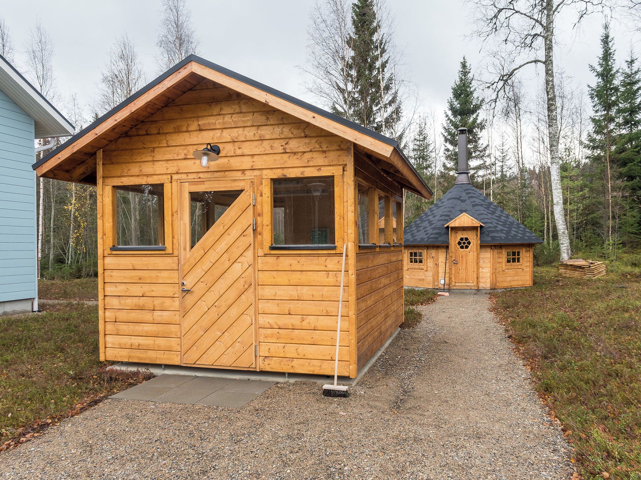 Une cabane en bois avec un toit à deux versants, une porte d’entrée et deux fenêtres.