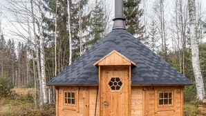 A wooden cabin with a hexagonal window, a chimney, and a door with a handle.