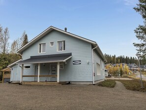 A two-story building with a porch, a sign reading 'TIMANTTI,' and a gravel driveway.