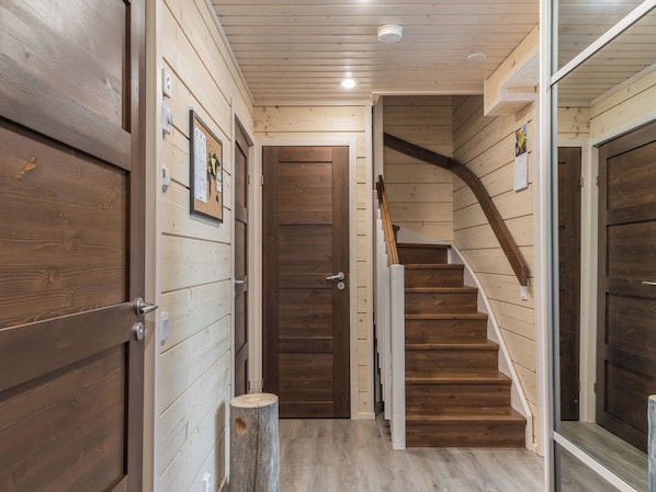 Een houten interieur met een trap naar een deur.