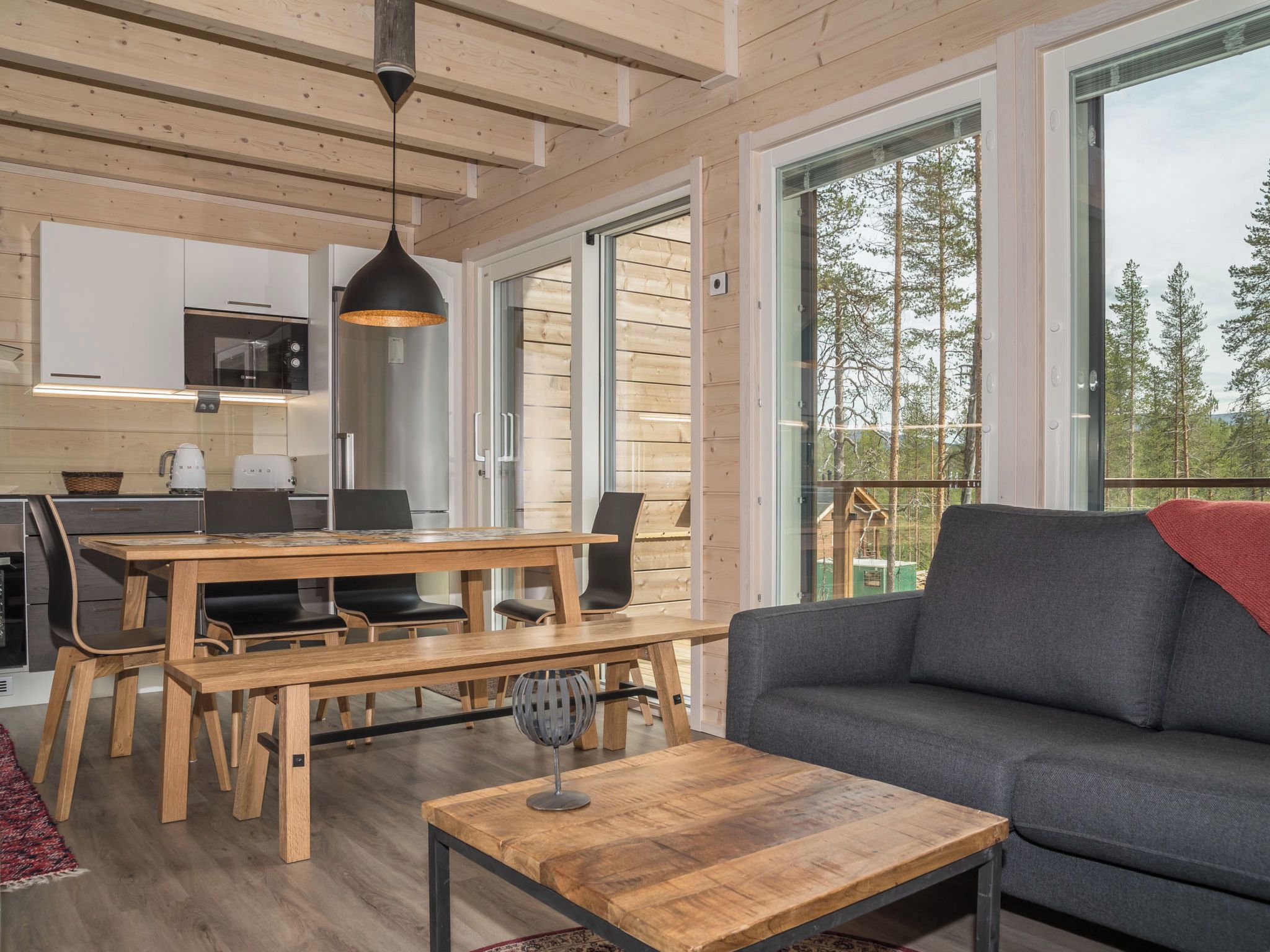 Een modern interieur met een houten eettafel, stoelen, een bank en een salontafel.