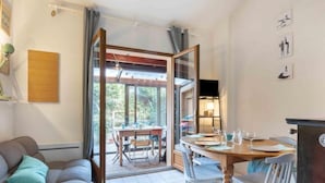 Ein gemütliches Wohnzimmer mit einer Couch, einem Esstisch mit Stühlen und einer Glastür zum Patio.