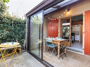 A cozy outdoor dining area with a glass door leading to a kitchen.