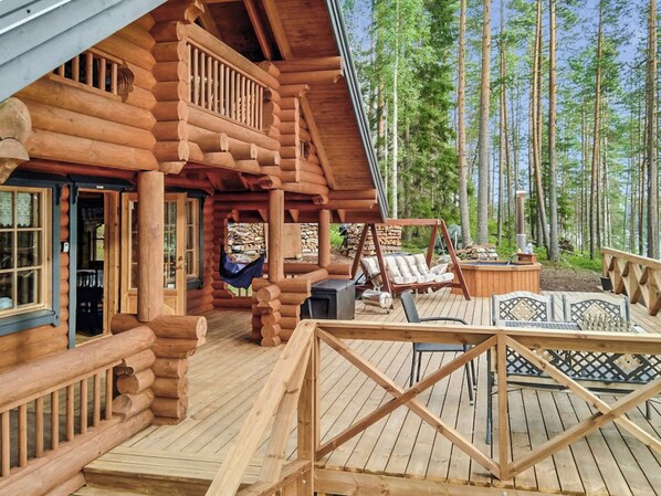 A log cabin with a deck, outdoor seating, and a fireplace. - Erätorsa by Interhome (Rautjärvi)