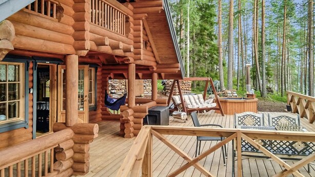 A log cabin with a deck, outdoor seating, and a hot tub. - Erätorsa by Interhome (Rautjärvi)