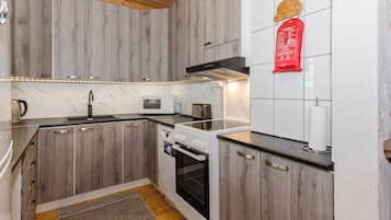 A kitchen with wooden cabinets, a microwave, a toaster, and an oven.