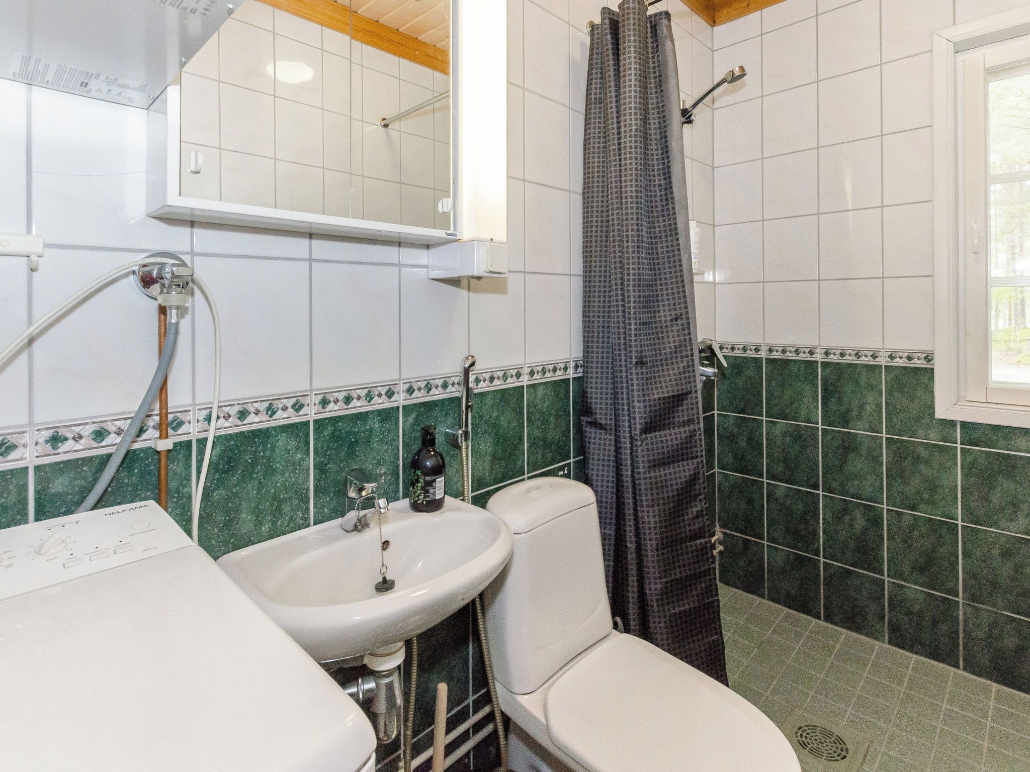 Kylpyhuone, jossa on valkoinen pesuallas, wc ja suihkutila.