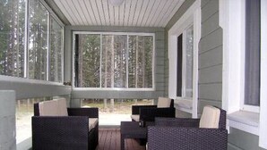 A covered porch with wicker furniture and large windows. - Kärkelä by Interhome (Kiuruvesi)
