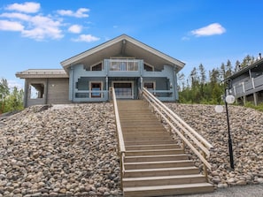 A two-story house with a wooden staircase leading to the front door. - Värikatti by Interhome (Sotkamo)