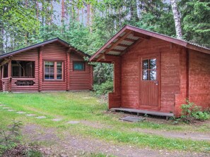 A rustic cabin with a porch and a separate shed, surrounded by a forested area. - Länsiranta by Interhome (Punkaharju)