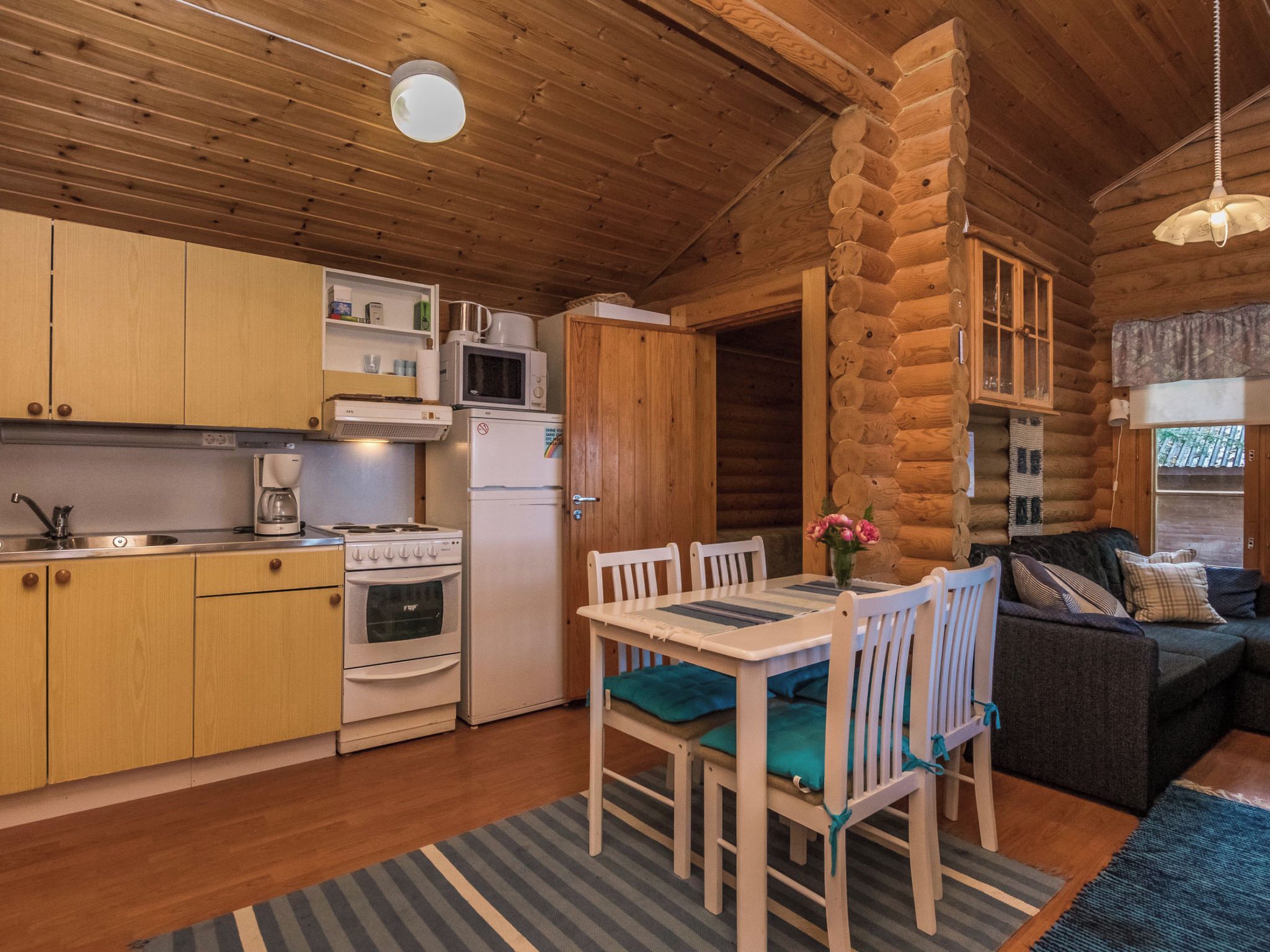A cozy cabin interior with a kitchen, dining area, and living space.