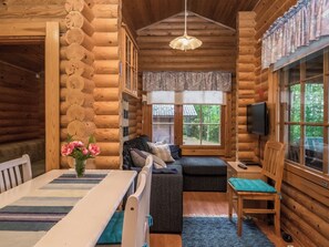A log cabin interior with a dining table, sofa, and a television. - Länsiranta by Interhome (Punkaharju)