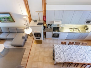 A compact living space with a kitchenette, a dining area, and a sofa.