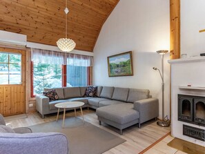 Ein gemütliches Wohnzimmer mit einer Eckcouch, einem runden Couchtisch und einem Kamin.