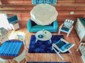 Una habitación acogedora con un sofá azul, una mesa redonda blanca y una alfombra azul.