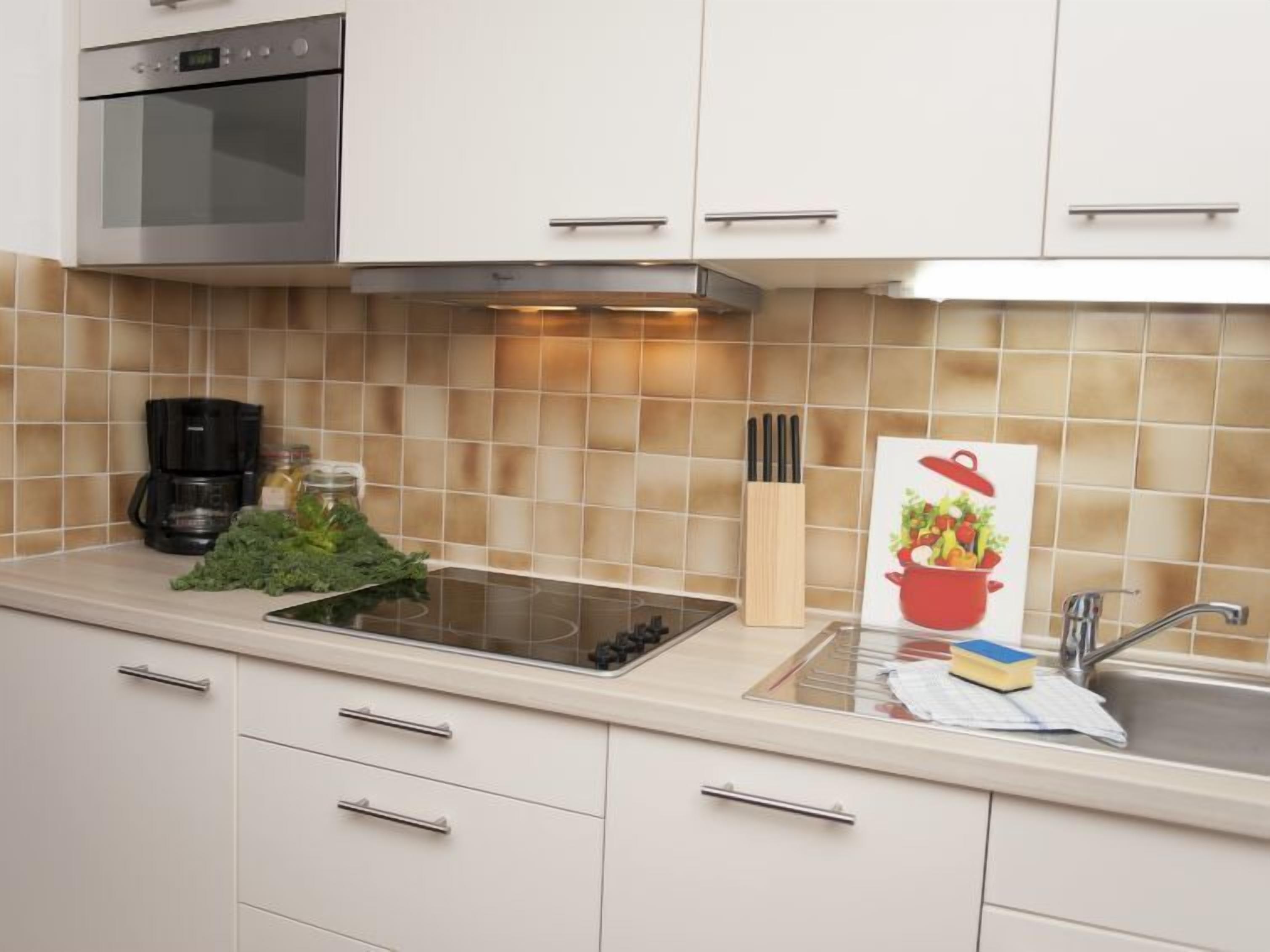 A modern kitchen with a built-in oven, a coffee maker, and a knife block.
