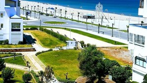 Un quartier résidentiel en bord de mer, avec des immeubles modernes, une plage et une vue dégagée sur l’océan.