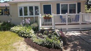 A single-story house with a front porch, a welcome sign, and a small garden with various plants and flowers. - NEW LISTING! - Quaint Cape May Beach House Only Blocks to the Beach (North Cape May)