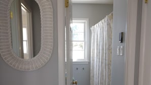 A hallway with a white door, a mirror, a patterned rug, and a shower with a curtain. - NEW LISTING! - Quaint Cape May Beach House Only Blocks to the Beach (North Cape May)