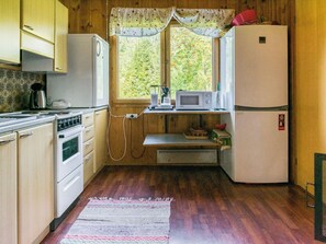 Una cocina funcional con armarios de madera, estufa, microondas y refrigerador.