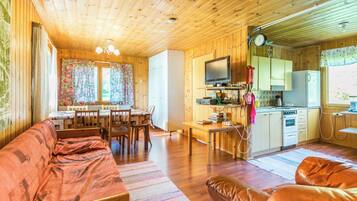 A cozy cabin interior with a living area, dining space, and kitchen.