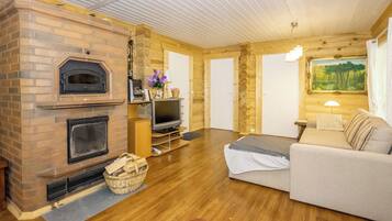 A cozy living room with a fireplace, a television, and a sofa.