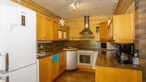 Une cuisine compacte avec des meubles en bois, un four encastré, un four à micro-ondes et une machine à café.