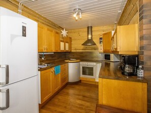 Een koelkast, een magnetron, kookgerei, borden en bestek