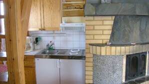 Keittiössä on kivinen takka, puukaapit ja ruostumattomasta teräksestä valmistettu jääkaappi.