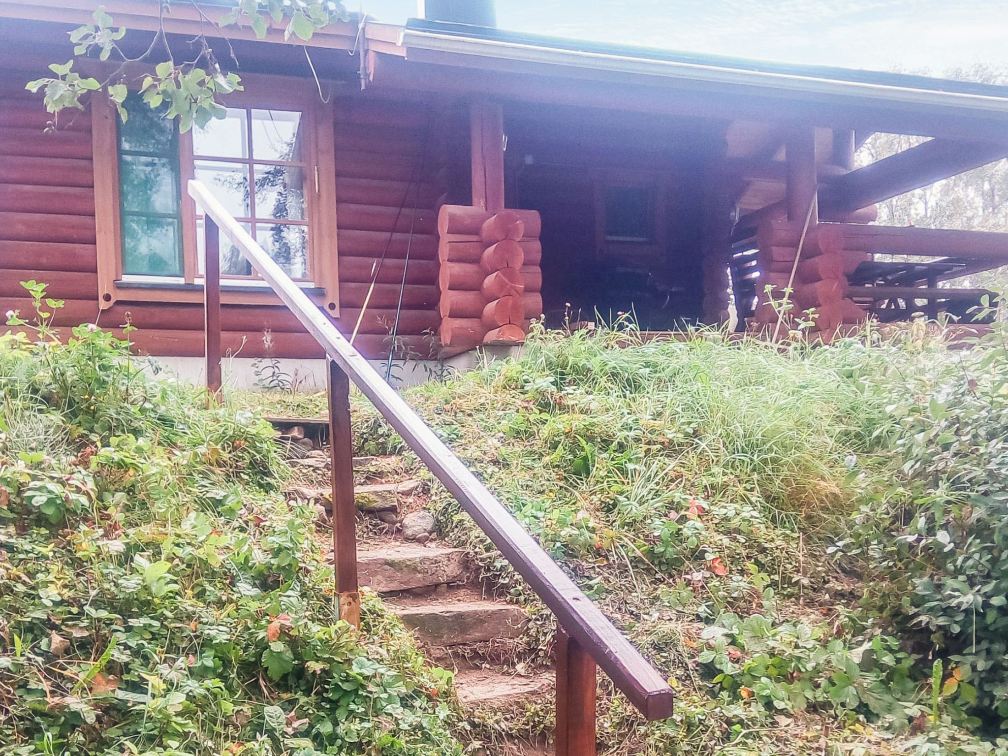 Un escalier en bois mène à une cabane dotée d’une véranda.