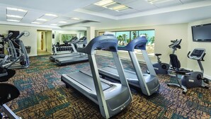 Ein Fitnessstudio mit Laufbändern, Crosstrainern und Kurzhanteln.