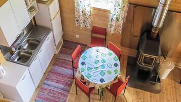 A compact kitchen with a stove, sink, and a dining area with a table and chairs.