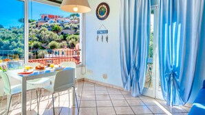 Ein Balkon mit Esstisch, Stühlen und Blick auf eine Hügellandschaft.