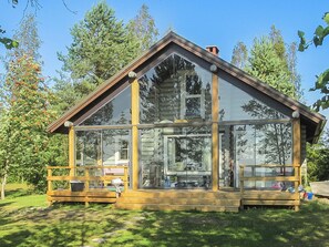 A log cabin with large windows, a wooden deck, and a chimney. - Tuulikannel by Interhome (Asikkala)