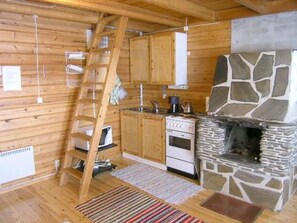 Eine Küche mit Holzausstattung, einem Herd und einem Steinkamin.