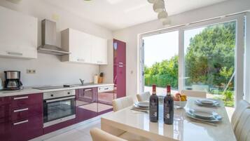 Een koelkast, een oven, een vaatwasser, kookgerei, borden en bestek